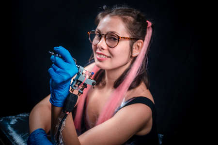 Master of the art of tattooing with a tattoo-machine in a tattoo studioの写真素材