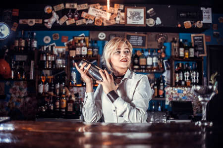 Girl bartender creates a cocktail at the barの写真素材