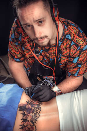 Tattoo master makes cool tattoo in tattoo studioの写真素材