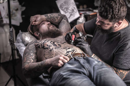 Tattoo master makes tattoo in tattoo studioの写真素材