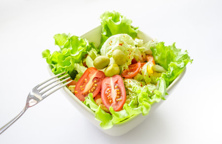 salad with vegetables and greens on white backgroundの写真素材