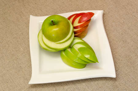 Sliced delicious apples on a white plateの写真素材