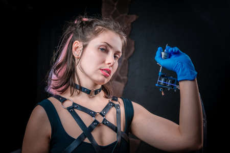 Professional tattooist with a tattoo gun in tattoo studioの写真素材