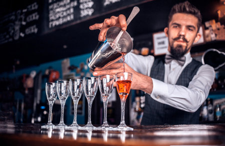 Confident barman makes a show creating a cocktail at the night clubの写真素材
