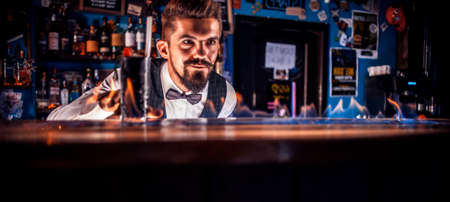 Experienced bartender adds ingredients to a cocktailの写真素材