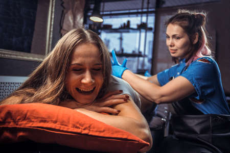 Professional tattooer working tattooing in tattoo studioの写真素材