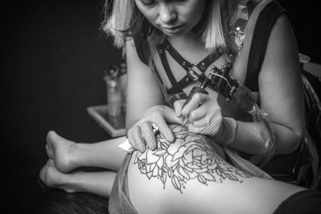 Master of the art of tattooing showing process of making a tattooの写真素材