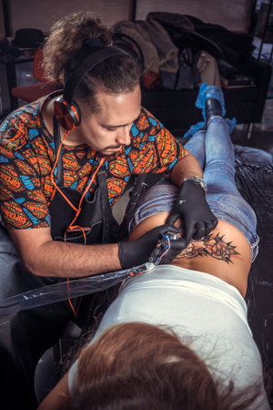 Master of the art of tattooing making a tattoo in tattoo parlourの写真素材
