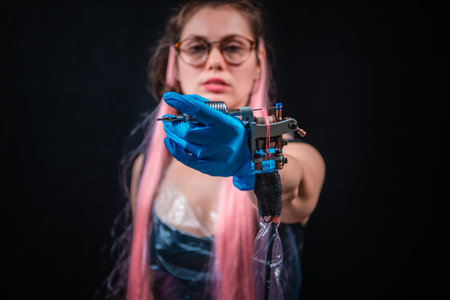 Professional tattoo artist and a tattoo gun in tattoo studioの写真素材
