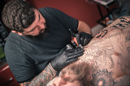Tattoo artist demonstrates the process of getting tattoo tattoo studioの写真素材