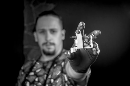 Tattooer poses for the camera in tatoo salonの写真素材
