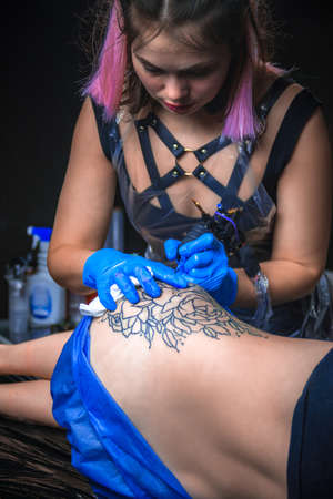 Tattooist doing tattoo in tattoo studioの写真素材