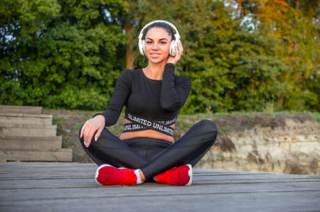 Beautiful sporty girl listens to musicの写真素材