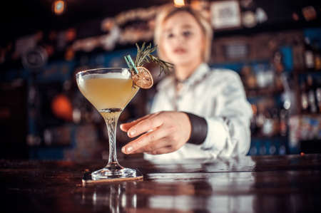 Young girl mixologist is pouring a drink in the nightclubの写真素材
