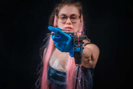 Tattoo artist with a tattoo-machine in studioの写真素材