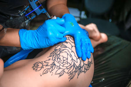 Professional tattooer working on professional tattoo machine gun in tattoo studioの写真素材