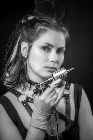 Master of the art of tattooing with a tattoo-machine in tattoo parlourの写真素材