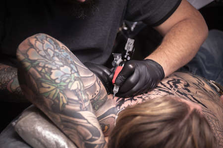 Professional tattooer at work in tattoo parlourの写真素材