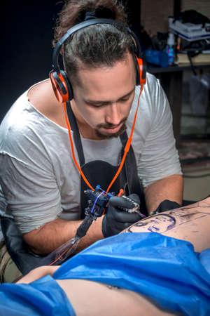 Tattooer creating a tattoo on his clientの写真素材