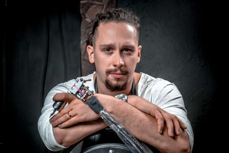 Master of the art of tattooing and a tattoo machine in tattoo studioの写真素材