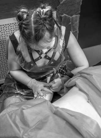 Master tattooist making a tattoo in tattoo parlourの写真素材