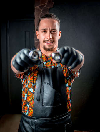 Tattoo master with a tattoo gun in the salonの写真素材