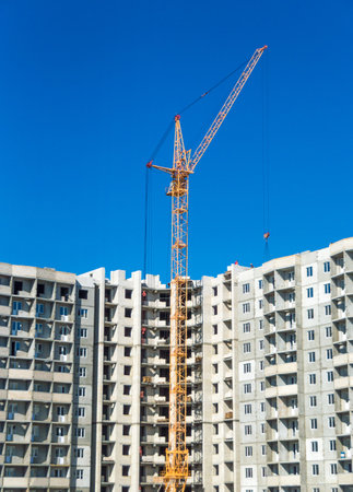 Tall cranes and multistorey housing under constructionの写真素材