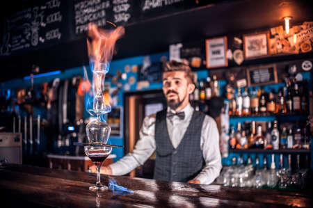 Portrait of bartending mixes a cocktail while standing near the bar counter in nightclubの写真素材