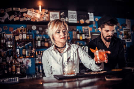 Pretty girl barkeeper creates a cocktailの写真素材