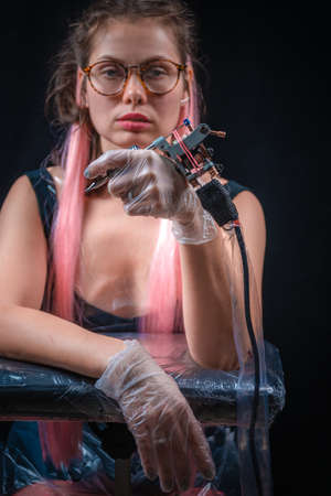 Tattoo artist and a tattoo gun in studioの写真素材