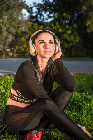 Cute sporty girl in headphones listening to musicの写真素材