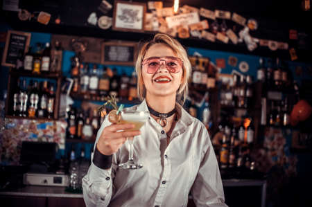Confident woman barman formulates a cocktail in cocktail barsの写真素材