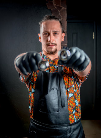 Professional tattooist with a tattoo gun in tattoo studioの写真素材
