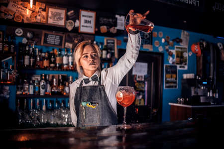 Girl bartender mixes a cocktail on the barの写真素材
