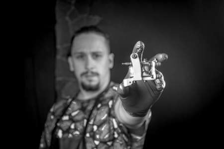 Master tattooist with a tattoo machine in tatoo salonの写真素材