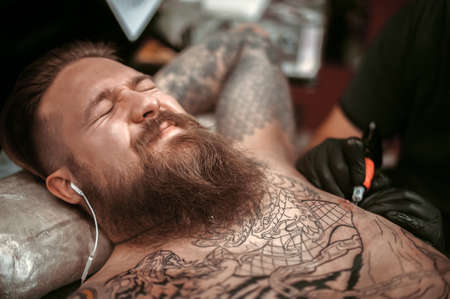 Professional tattooist makes a tattoo in a tattoo parlorの写真素材