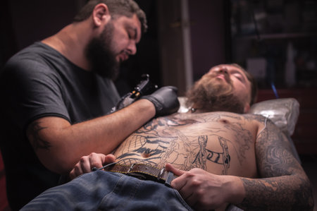 Professional tattooist draws a tattooの写真素材