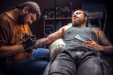 Professional tattoo artist working tattooing in tattoo parlourの写真素材