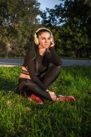 Emotional young woman with headphones outdoors enjoying musicの写真素材