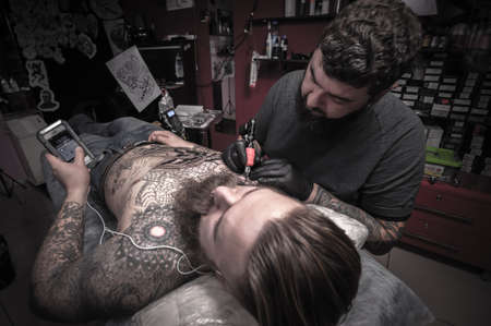 Professional tattoo artist does a tattoo in the Studioの写真素材