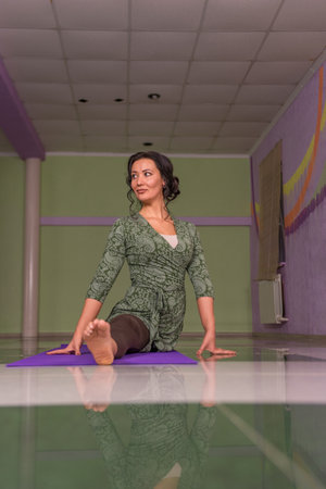 Woman shows yoga exercises in fitness classの写真素材