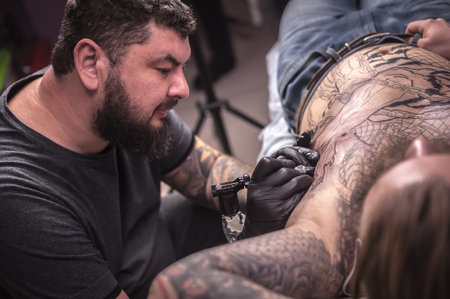 Master of the art of tattooing posing in tattoo studioの写真素材
