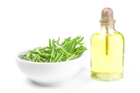 Oil in a bottle and fresh organic rosemary isolated on whiteの写真素材
