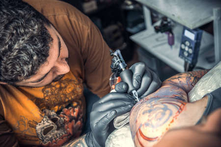 Professional tattoo artist works in tattoo parlorの写真素材