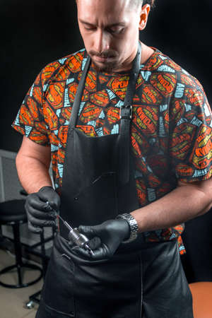 Tattoo artist poses for the camera in tattoo studioの写真素材