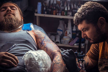 Tattooist makes tattoo in studioの写真素材