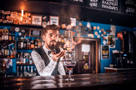 Experienced tapster makes a show creating a cocktail at the nightclubの写真素材