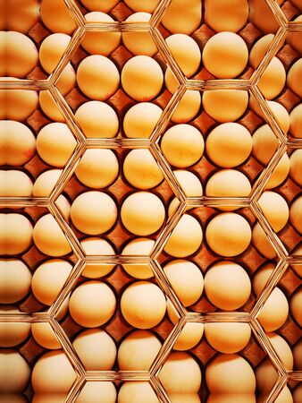 image full top down view of tray or carton full of many raw eggs with creative imaginative transformations to create hexagonal patterns and designsの写真素材