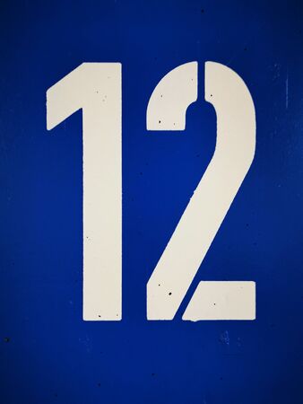 huge white number numerical 12 twelve on royal blue backgroundの写真素材