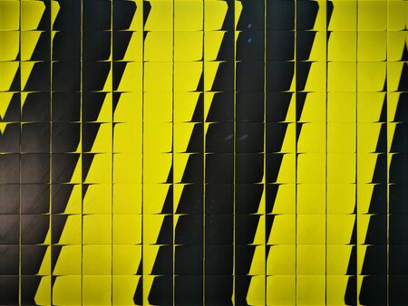 intricate rectangular mosaic tiles variations through design all based on multiple black diagonal on a vibrant yellow chevronの写真素材